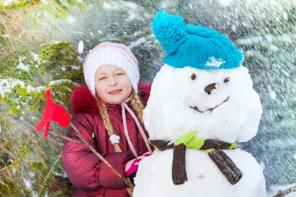 Fille avec bonhomme de neige et flocons de neige — Photo