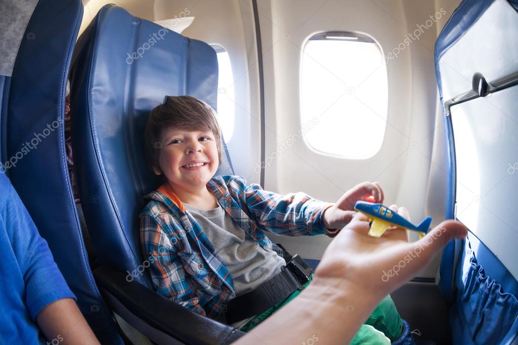 Boy take toy plane in airplane