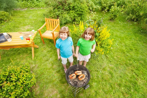 Twee gelukkige meisjes grillen van vlees — Stockfoto