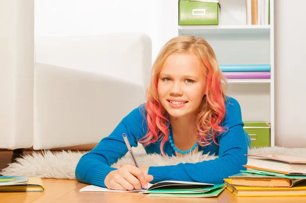 Smart blond girl does homework — Stock Photo, Image