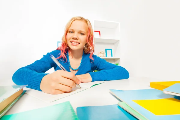 Happy blond girl does homework — Stock Photo, Image