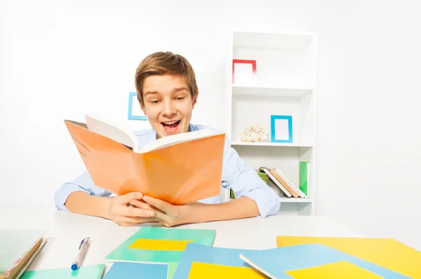 Handsome teen boy reads book — Stock Photo, Image