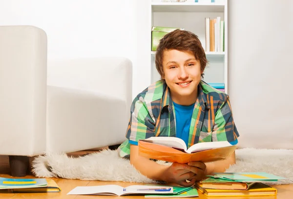 Lachende knappe jongen doet huiswerk — Stockfoto