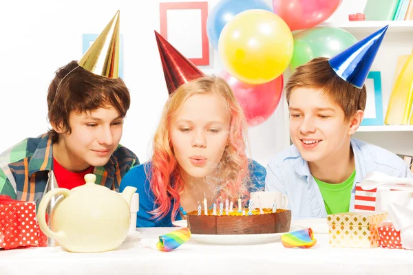 Adolescente chica soplando pastel velas — Foto de Stock