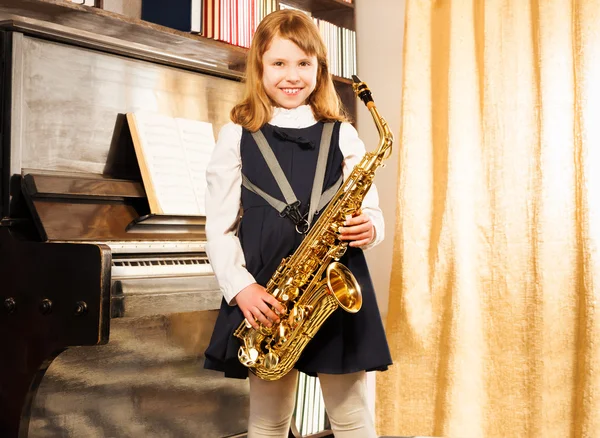 Gelukkig meisje houdt altsaxofoon — Stockfoto