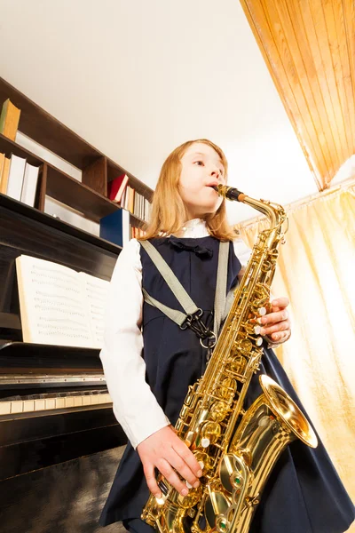 Девушка играет на альт-саксофоне — стоковое фото