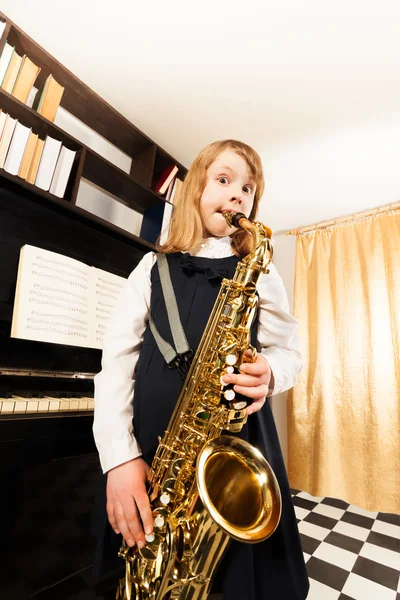 Маленькая девочка играет на альт-саксофоне — стоковое фото