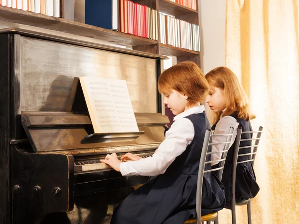 Two beautiful girls playing piano — Stock Photo, Image