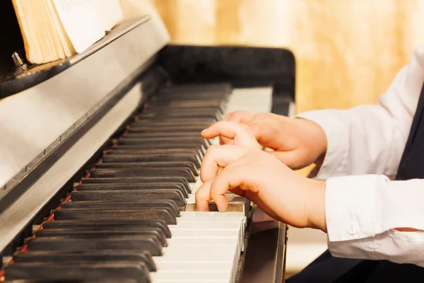 Childs hands playing on piano-keys — Stock Photo, Image