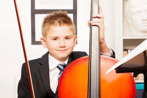 Chico sosteniendo violín, tocando violonchelo — Foto de Stock