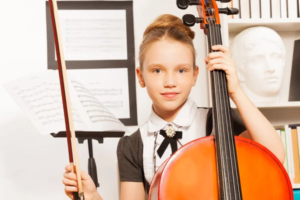 Chica sosteniendo violín-arco para tocar el violonchelo — Foto de Stock