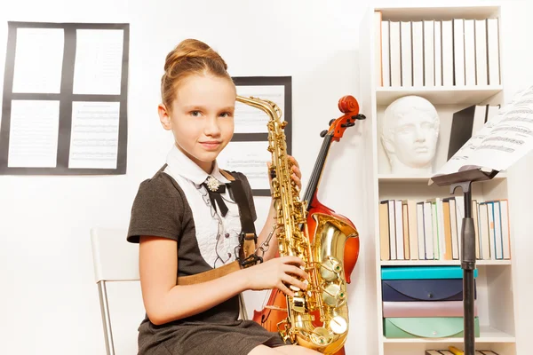 Leuk meisje houdt saxofoon — Stockfoto