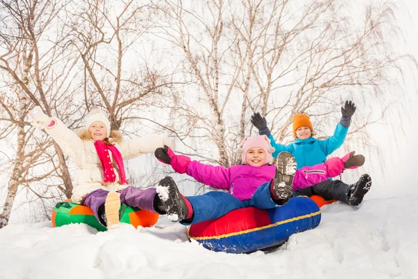 Excited children sliding down on tubes — Stockfoto