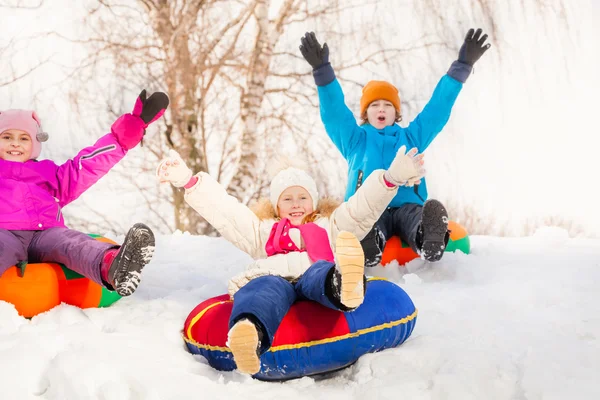 Children sliding down on tubes — Stock fotografie