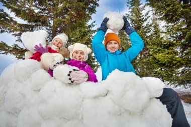 Group of happy children hold snowballs