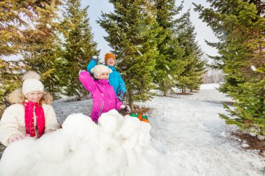 Girls and boy playing snowballs game