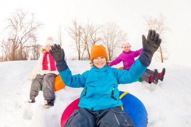 Boy and girls sliding down on tubes