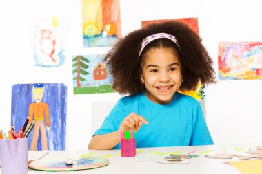 Small African girl sits at table clipart