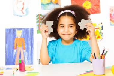 African girl holds puzzle pieces