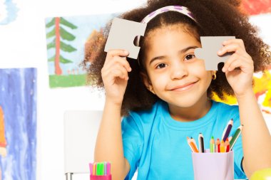 African girl holding puzzle pieces