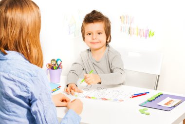 small boy holds pencil