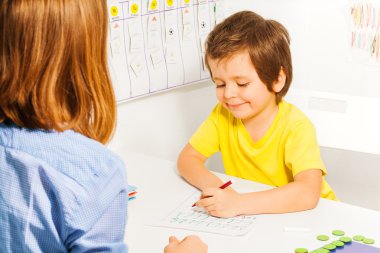 Boy in yellow T-shirt with pencil