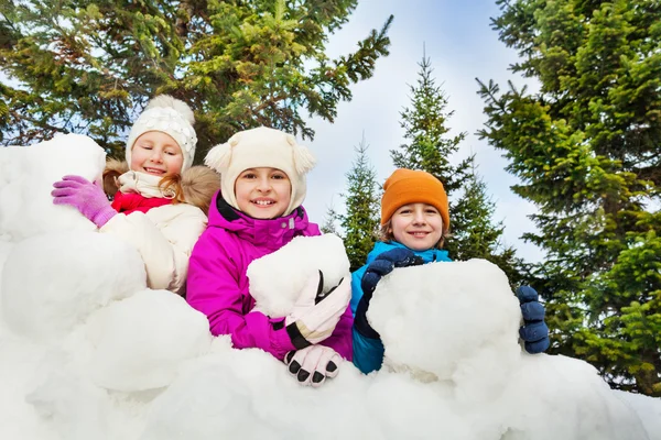 Happy kids behind snow fort — 图库照片