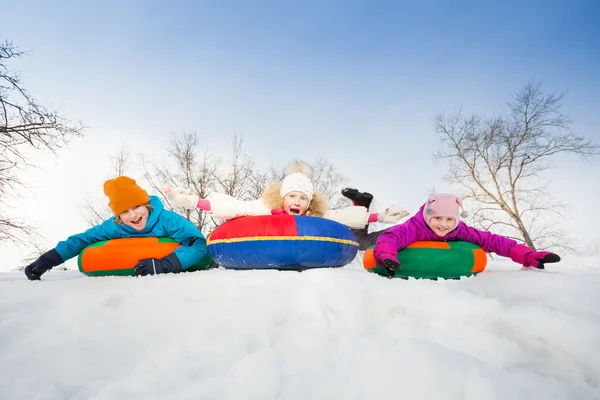 Happy group of children slide on tubes — Stock fotografie