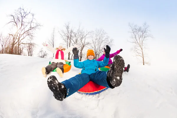 Boy and girls sliding down on tubes — 图库照片