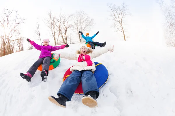 Children sliding down on tubes — Stockfoto