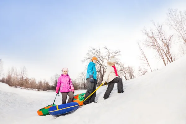 Kinder laufen den verschneiten Hügel hinauf — Stockfoto