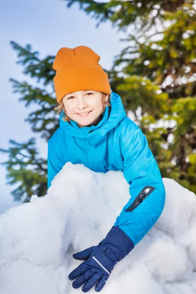 Menino feliz atrás da parede de neve — Fotografia de Stock