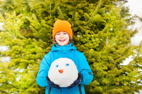 Skrattande pojke håller snowmans huvud — Stockfoto