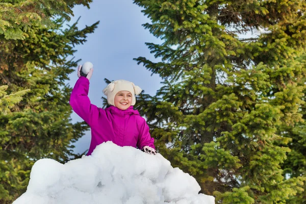 Chica con bola de nieve detrás de la pared de nieve —  Fotos de Stock