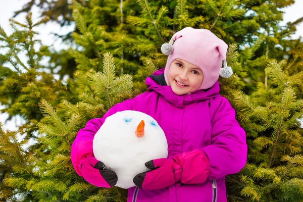 Lachende meisje snowmans hoofd houden — Stockfoto