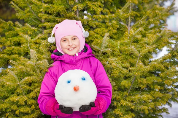 Meisje snowmans hoofd houden in bos — Stockfoto