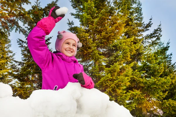 Flicka som är redo att kasta snöboll i skogen — Stockfoto