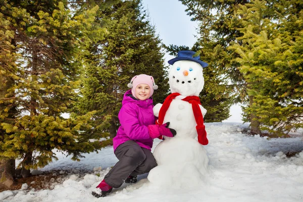 Красивая маленькая девочка и снеговик — стоковое фото