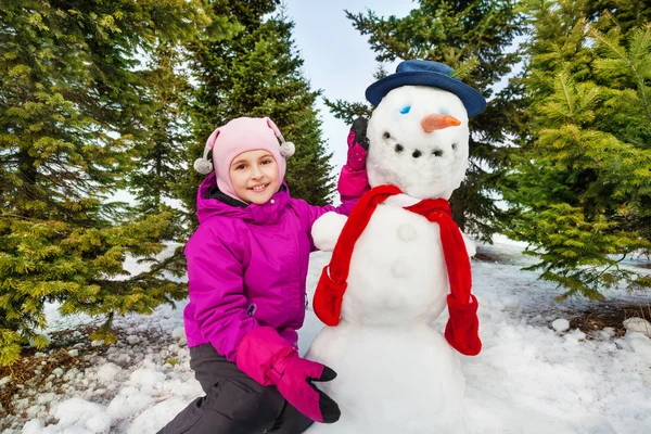 Beautiful girl and cute snowman — Stock Photo, Image