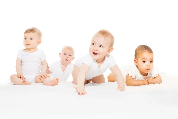 Cuatro bebés lindos se arrastran en fila — Foto de Stock