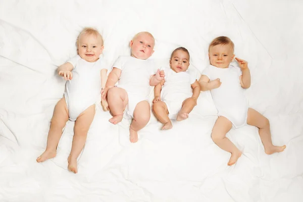 Четыре младенца лежат в ряд — стоковое фото