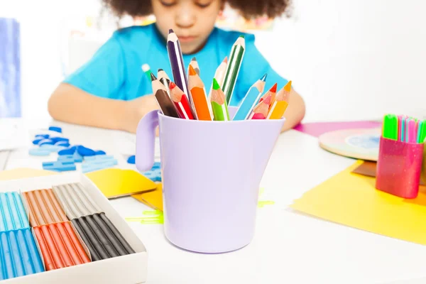 Pencils and African girl writing — Stok fotoğraf