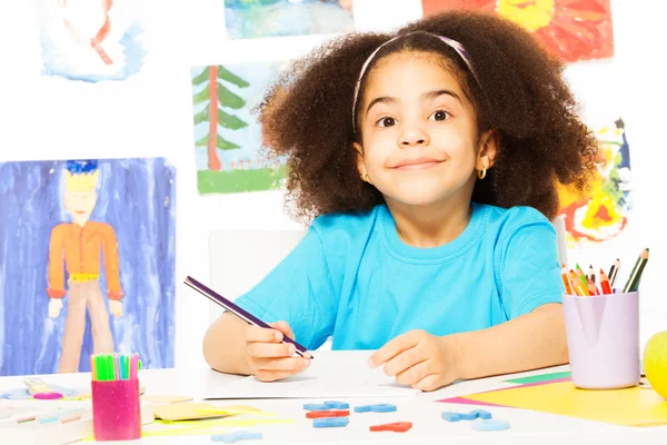 Cute smiling African girl writing — Stock Photo, Image