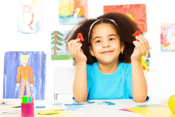 Cute African girl shows letters — Stock Photo, Image