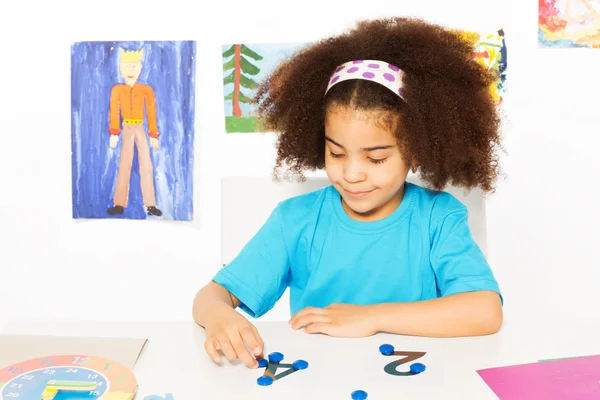 Girl puts blue coins — Stock Photo, Image