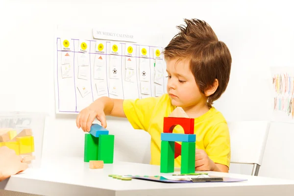 Мальчик кладет красочные кубики — стоковое фото
