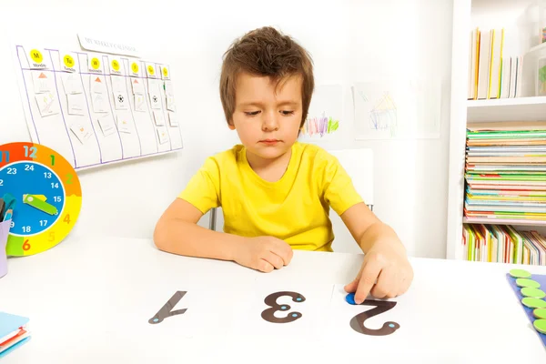 Jongen leert om te tellen met munten — Stockfoto