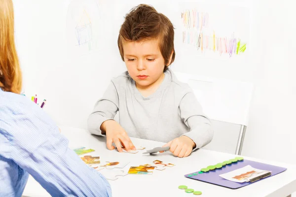 Niño concentrado resolver tarjetas de puzzle — Foto de Stock