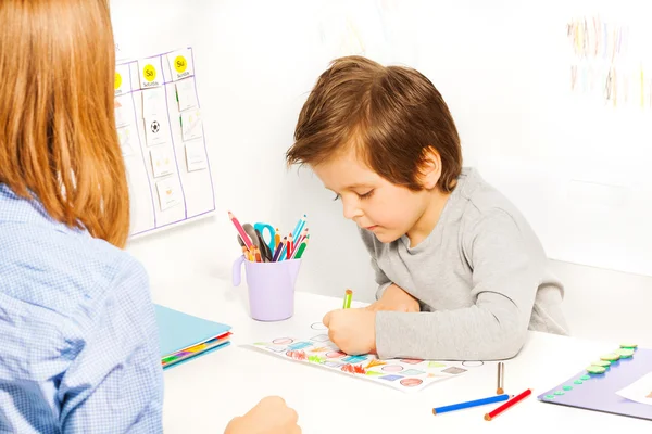 Boy holds pencil and colors shapes — Φωτογραφία Αρχείου