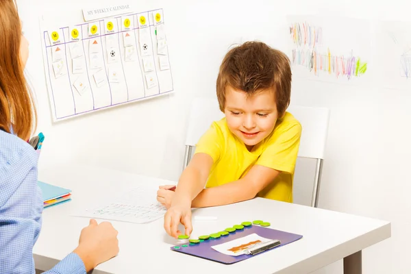 Lächelnder Junge steckt Münzen — Stockfoto